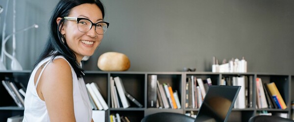 Asian woman working on laptop smiling